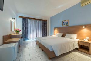 a bedroom with a large bed and a window at HOTEL TINA FLORA in Kolymbia