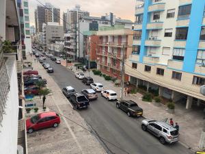 uma rua da cidade cheia de carros estacionados em Excelente Localização Apto 1 dorm sacada de frente em Capão da Canoa