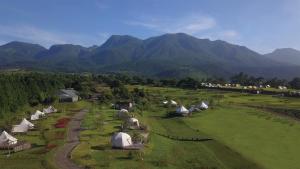 uma vista aérea de tendas num campo com montanhas em くじゅう花公園　キャンピングリゾート花と星 em Kuju