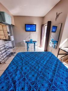 Schlafzimmer mit einem blauen Bett und einem Tisch in der Unterkunft Cómodo Apartamento privado in Tegucigalpa