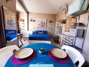 a room with a blue table and chairs and a bed at Cómodo Apartamento privado in Tegucigalpa