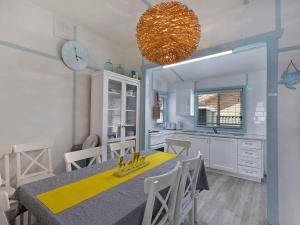 a kitchen and dining room with a table and a clock at Pacific Family Retreat in Long Jetty