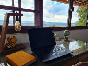 a laptop computer sitting on a desk in front of a window at Morada do Chabeco in Lavras Novas