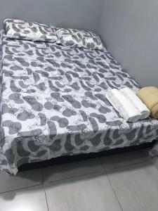 a bed with a black and white comforter at Sal-beach in Salinópolis