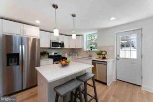 uma cozinha com armários brancos e electrodomésticos de aço inoxidável em Brand new home in South Philly!!! em Filadélfia