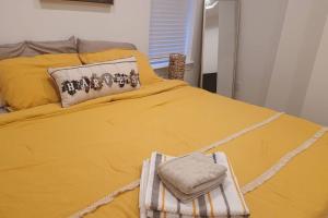a yellow bed with two towels on top of it at Brand new home in South Philly!!! in Philadelphia