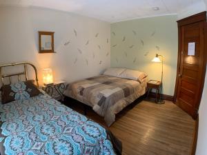 ナイアガラフォールズにあるワンダーフォールズ ゲストハウス ＆ ホステルのベッドルーム1室(ベッド2台、ランプ、ドア付)