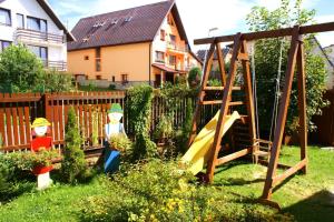 un patio con parque infantil con tobogán en Vila Ema, en Nová Lesná