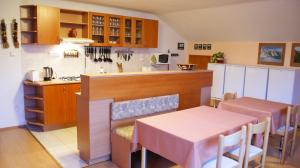 a kitchen and dining room with a table and a counter at Vila Ema in Nová Lesná