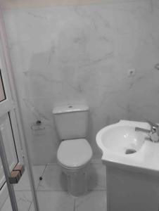 a white bathroom with a toilet and a sink at Cosy 2 bedroom home in the heart of Jardim do Mar in Jardim do Mar