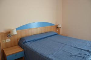 1 dormitorio con 1 cama con colcha azul en Hotel Lisa, en Pineto