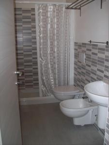 ein Badezimmer mit 2 WCs, einem Waschbecken und einer Dusche in der Unterkunft Hotel Lisa in Pineto
