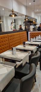 a row of tables and chairs in a restaurant at Hôtel Le Clemenceau Centre ville -Sncf in Valenciennes