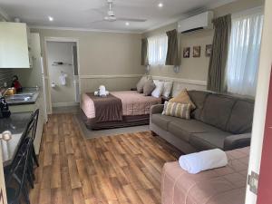 een woonkamer met een bed en een bank bij NRMA Atherton Tablelands Holiday Park in Atherton