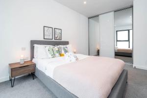 Un dormitorio blanco con una cama grande y una mesa en Candy-Chic 1 Bedroom Apartment - City Centre, en Birmingham