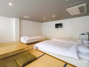 Postel nebo postele na pokoji v ubytování Iwatoyama Hostel
