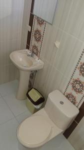 a bathroom with a white toilet and a sink at Hotel Jose Antonios Inn in Puerto Maldonado