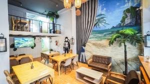 a restaurant with tables and a mural of a beach at Hoft Hostel Bangkok in Bangkok