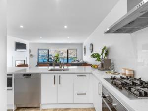 a white kitchen with a sink and a stove at St Matthews Views Walter in Queenstown
