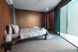 a bedroom with a bed and a large window at Pondok Beach Shack in Tioman Island