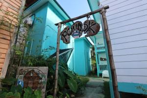 a street sign in front of a blue house at Pondok Beach Shack in Tioman Island