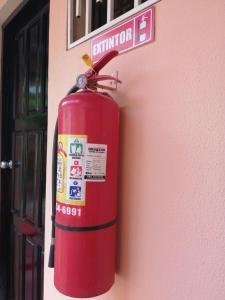 una boca de incendios roja al lado de un edificio en Hostal Mariella en Estelí