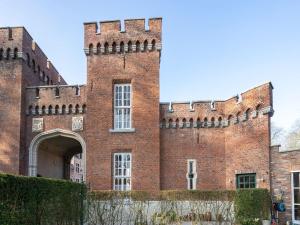 a large red brick building with an archway at Apartment in Kruibeke at Wissekerke Castle in Kruibeke