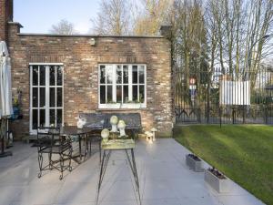 a patio with a table and chairs in front of a brick building at Apartment in Kruibeke at Wissekerke Castle in Kruibeke