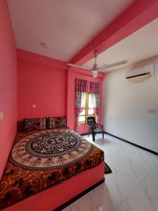 a bedroom with a large bed with pink walls at BEACH LIFE UPPUVELI in Trincomalee