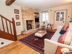 a living room with a couch and a fireplace at Royal Oak Cottage in Chipping Campden