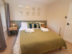 a bedroom with a large bed with two pillows at Royal Oak Cottage in Chipping Campden