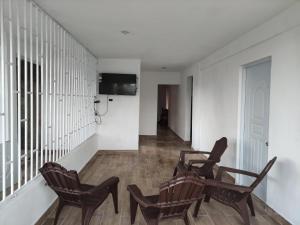 a room with three chairs and a television on a wall at Samana house in Santa Bárbara de Samaná