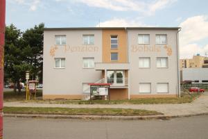 un gran edificio blanco con un cartel. en Penzion Bobule, en Staré Město