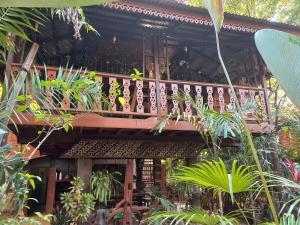 a wooden balcony of a house with plants at Teak house Chiang Mai in Chiang Mai