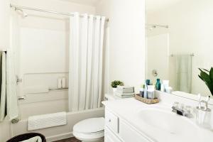 Baño blanco con aseo y lavamanos en InTown Suites Extended Stay Mobile- South Beltine en Mobile
