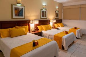 Cette chambre d'hôtel comprend 3 lits avec des draps jaunes. dans l'établissement Hotel San Antonio, à Aguascalientes