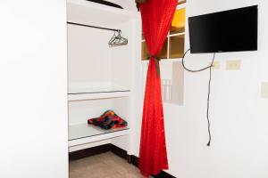 Habitación con TV y cortina roja. en Hostal San José en Somoto