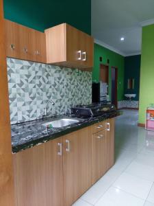 a kitchen with wooden cabinets and a sink at Rabbani Family Homestay in Yogyakarta