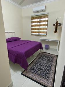 une chambre avec un lit violet et une fenêtre dans l'établissement D`Cycas Homestay Pulau Indah, à Pulau Indah