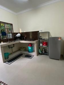 une cuisine avec un réfrigérateur en acier inoxydable dans une pièce dans l'établissement D`Cycas Homestay Pulau Indah, à Pulau Indah