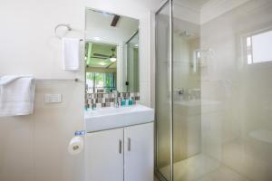 a bathroom with a shower, sink, and mirror at NRMA Agnes Water Holiday Park in Agnes Water