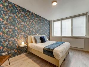 1 dormitorio con 1 cama grande y papel pintado con motivos florales en Lovely Holiday Home in Roesbrugge with Sauna and bubble bath, en Roesbrugge-Haringe