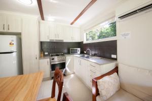 a kitchen with a stove top oven and a refrigerator at NRMA Agnes Water Holiday Park in Agnes Water