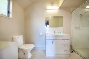 a bathroom with a toilet and a sink and a shower at NRMA Agnes Water Holiday Park in Agnes Water +40 photos