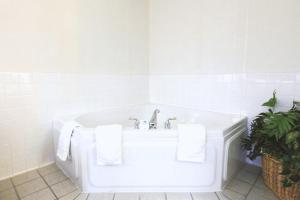 a white bath tub sitting next to a white toilet at Coratel Inn & Suites by Jasper Northfield in Northfield