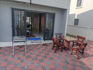 a patio with a table and two chairs and a table at Mulberi Homestay 4BR 3Bth(8-10 px) in Port Dickson +8 photos