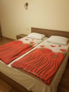 a bed with a red blanket on top of it at Vernisaj apt at Republic Square & Ruben tours in Yerevan