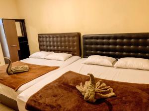 Omah Pelem Syariah في سيمارانغ: سريرين في غرفة عليها مناشف