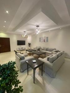 a living room with couches and a flat screen tv at sun sets for family only in Durat  Alarous