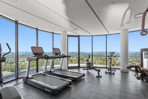 un gimnasio con cintas de correr y elípticas en un edificio con ventanas en The Gallery Residences Broadbeach en Gold Coast